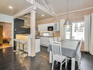 a kitchen and dining room with a table and chairs at Holiday Home Villa utu by Interhome in Kolinkylä +25 photos