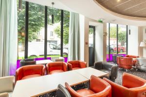 a waiting room with tables and chairs and windows at Best Western Hotel San Benedetto in Cholet