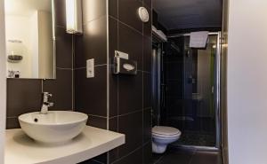 a bathroom with a sink and a shower and a toilet at Best Western Hotel San Benedetto in Cholet +51 photos