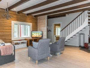 a living room with two chairs and a tv at Holiday Home Rantala by Interhome in Ranua +15 photos