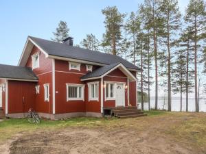 a red house with a bike parked in front of it at Holiday Home Rantala by Interhome in Ranua
