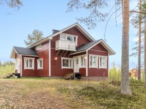 a home with a red house with a balcony at Holiday Home Rantala by Interhome in Ranua