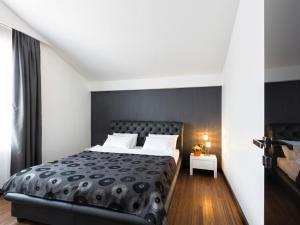 um quarto com uma cama preta e almofadas brancas em Nova City Garni Hotel Signature Collection em Belgrado