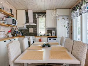 a kitchen with a table and chairs and a refrigerator at Holiday Home Tuliniemi by Interhome in Iisalmi