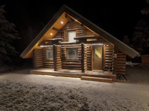 a log cabin in the snow at night at Holiday Home Vanttausranta by Interhome in Vanttauskoski