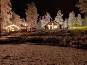 a log cabin in the snow at night at Holiday Home Vanttausranta by Interhome in Vanttauskoski