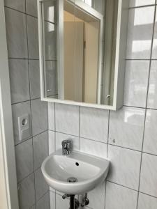 a bathroom with a white sink and a mirror at Hotel Lahnblick in Weilburg