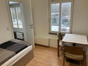 a room with a bed and a table and window at Hotel Lahnblick in Weilburg