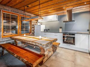 a kitchen with a wooden table and a wooden bench at Holiday Home Kelohippu 2 by Interhome in Pyhätunturi
