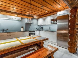 a kitchen with a table and a wooden ceiling at Holiday Home Kelohippu 2 by Interhome in Pyhätunturi