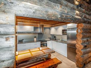 a kitchen with a wooden wall and a wooden bench at Holiday Home Kelohippu 2 by Interhome in Pyhätunturi