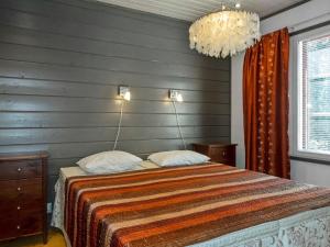 a bedroom with a bed and a chandelier at Holiday Home Kelkka 2 by Interhome in Salla