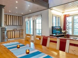 a living room with a table and a kitchen with windows at Holiday Home Kelkka 2 by Interhome in Salla
