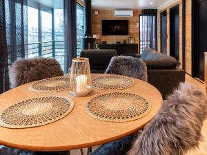 a wooden table with chairs and a table with plates on it at Holiday Home Saanan lumous by Interhome in Kilpisjärvi