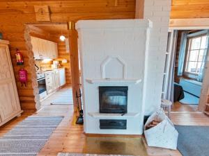 a living room with a fireplace in a house at Holiday Home Lompakko by Interhome in Äkäslompolo