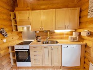 a kitchen with wooden cabinets and a sink at Holiday Home Lompakko by Interhome in Äkäslompolo +21 photos