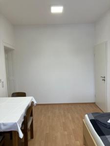 a white room with a table and a bed in it at Hotel Lahnblick in Weilburg +6 photos