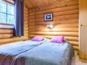 a bedroom with a bed in a log cabin at Holiday Home Pyhäkolo by Interhome in Pyhätunturi