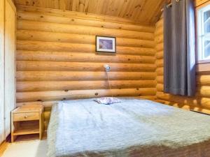 a bedroom with a bed in a log cabin at Holiday Home Pyhäkolo by Interhome in Pyhätunturi