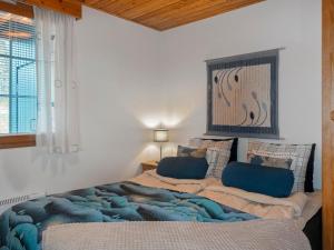 a bedroom with a bed with a blue blanket and a window at Holiday Home Siulapalkinen a 4 by Interhome in Saariselka