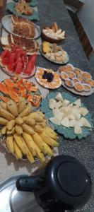 a table topped with plates of food with bananas at Kuawit Hotel in Aragarças
