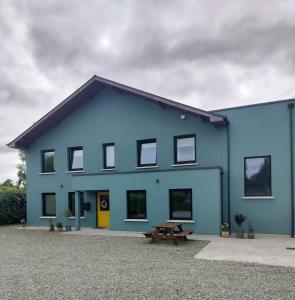 a blue building with a picnic table in front of it at Cedar Lodge in Killarney