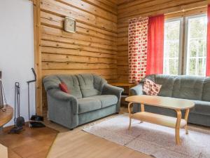 a living room with two chairs and a table at Holiday Home Kranni 2 by Interhome in Syöte +13 photos