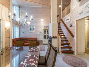 a dining room and living room with a chandelier at Holiday Home Otsonherra by Interhome in Pyhätunturi
