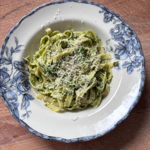 a plate of pasta with pesto on a table at Ayur Garden Lanckorona in Lanckorona