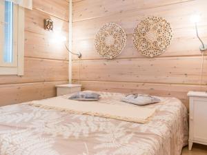 a bed in a room with wooden walls at Holiday Home Otsonherra by Interhome in Pyhätunturi +10 photos