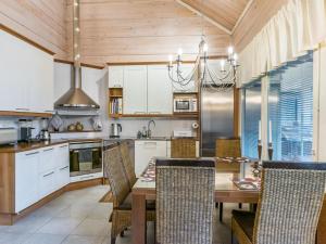 a kitchen with a wooden ceiling and a table with chairs at Holiday Home Otsonherra by Interhome in Pyhätunturi