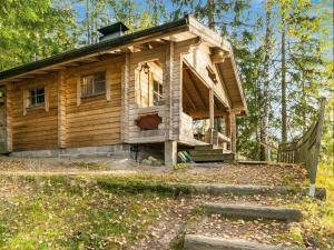 a log cabin in the woods with a porch at Holiday Home Lossitupa by Interhome in Iitti