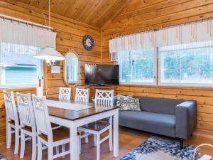 a dining room with a table and a couch at Holiday Home Pyhä-vuonelo by Interhome in Pyhätunturi