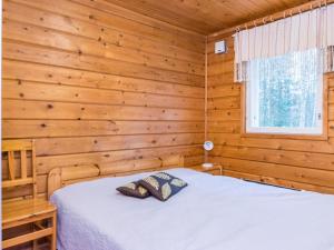 a bedroom with a bed in a log cabin at Holiday Home Pyhä-vuonelo by Interhome in Pyhätunturi