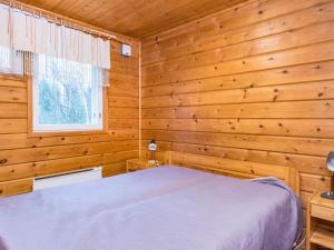 a bedroom with a bed in a log cabin at Holiday Home Pyhä-vuonelo by Interhome in Pyhätunturi