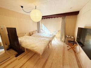 a bedroom with a large bed and a television at なごらーれ放生津屋 in Shimminato
