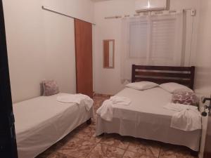 a bedroom with two beds and a window at Kuawit Hotel in Aragarças