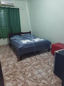 a bedroom with a bed with towels on it at Kuawit Hotel in Aragarças +17 photos