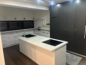 a kitchen with white counters and black cabinets at Apartmen Emina in SJJ