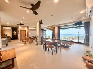 a living room with a dining table and a view of the ocean at Zenith Retreat in Xiaoliuqiu