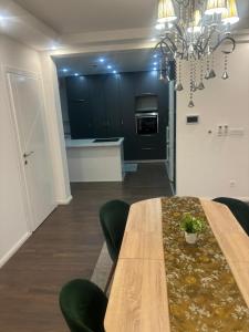 a dining room with a wooden table and green chairs at Apartmen Emina in SJJ