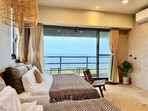 a bedroom with a bed and a view of the ocean at Zenith Retreat in Xiaoliuqiu