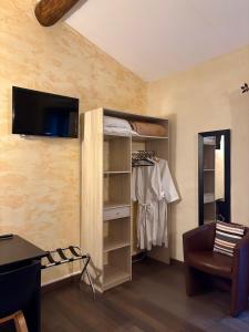 a room with a closet with a tv on a wall at Logis Hotel Restaurant L'Esquielle in Saint-Géniès-de-Malgoirès