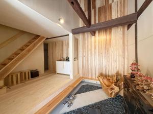 an attic room with wooden floors and a staircase at なごらーれ放生津屋 in Shimminato