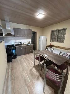 a kitchen with a wooden table and a dining room at El Atardecer in Trapiche