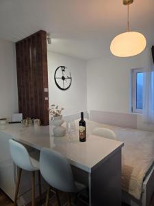 a kitchen with a table with chairs and a clock at Sky Nest Kopaonik in Kopaonik