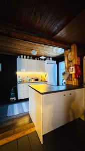 a kitchen with white cabinets and a black counter top at Savupirtti 1819 in Pudasjärvi