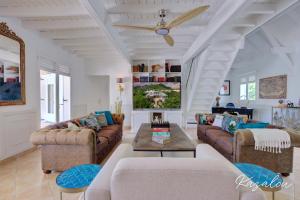 a living room with couches and a ceiling fan at Villa Kazalou in Saint Martin
