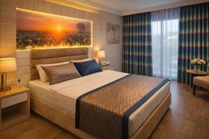 a bedroom with a bed with a painting on the wall at Oji Beach Hotel in Hacılar