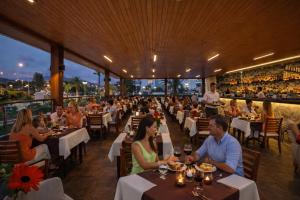 a group of people sitting at tables in a restaurant at Oji Beach Hotel in Hacılar